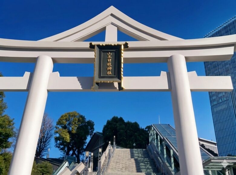 赤坂・日枝神社の特徴的な白い山王鳥居と、澄み渡る青空へ続く参道の階段